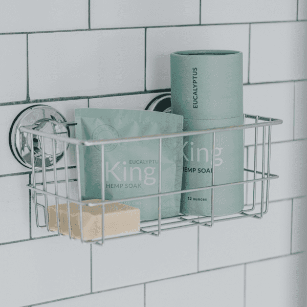 The King collection of Soaks and Body Bar in a bath caddy attached to a shower.