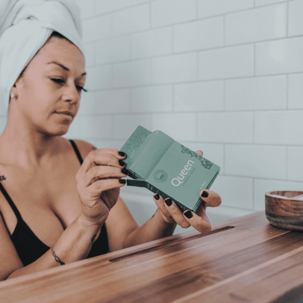 A woman taking a bath with the Queen body bar.